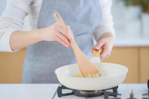 ターナーで炒めている人の手 ターナーで炒めている人の手 玉ネギ,炒める,みじん切りの写真素材