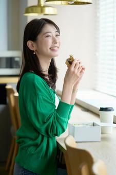 カフェでサンドイッチを食べる日本人女性 カフェでサンドイッチを食べる日本人女性 日本人,女性,スマイルの写真素材