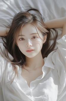 ベッドに仰向けに寝る可愛い日本人の女性の写真