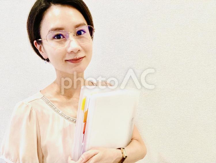 バインダーを持って微笑むメガネの女性 女性,キャリア,女子の写真素材