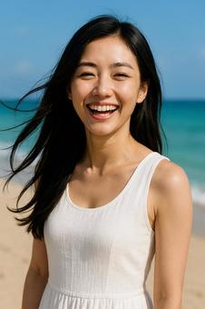 夏のビーチで笑顔を見せる白ワンピース女性 夏のビーチで笑顔を見せる白ワンピース女性の写真