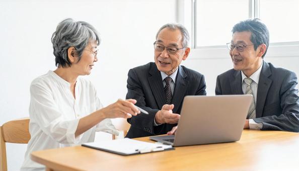 対面でPCでプランを説明するビジネスマンの写真