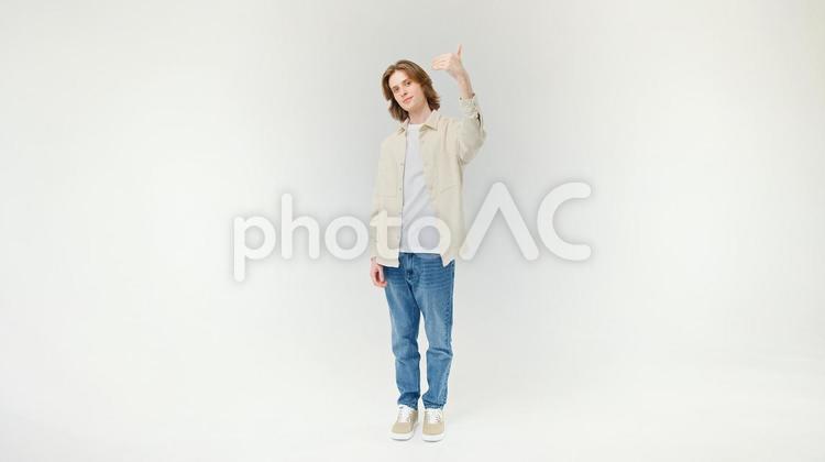 カメラ目線で左手でポーズする外国人男性 男性,ポーズ,サムズアップの写真素材