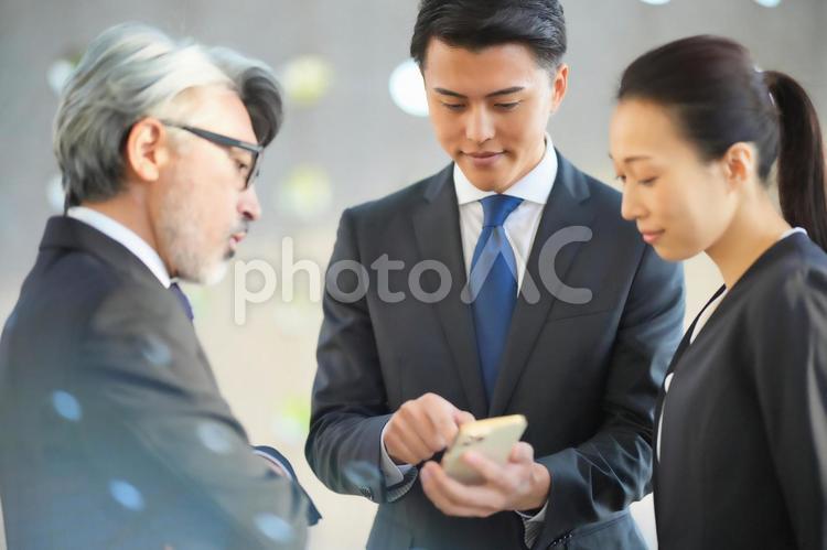 スマートフォンを見ながら話す上司と部下 ビジネスマン,チーム,同僚の写真素材