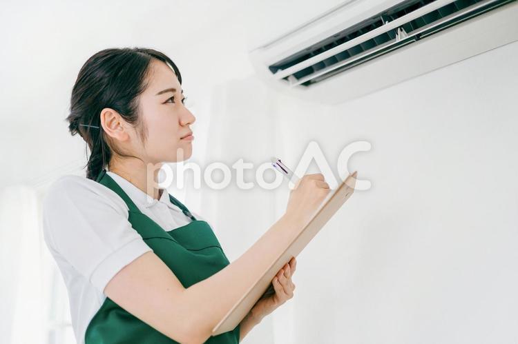 エアコンをチェックする女性（困る） エアコン,空調,困るの写真素材