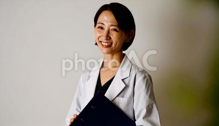 ファイルを抱える笑顔の日本人女性看護師 看護士,若い,白衣の写真素材