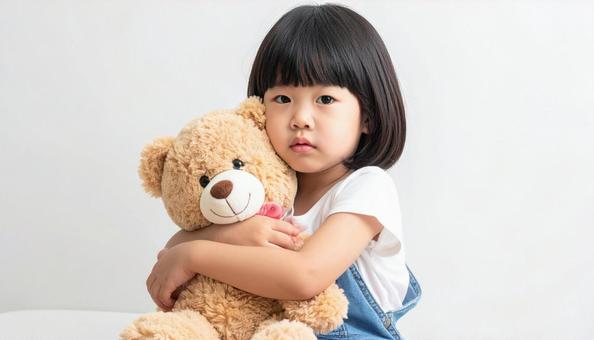 お気に入りのクマのぬいぐるみを抱く子供 お気に入りのクマのぬいぐるみを抱く子供の写真