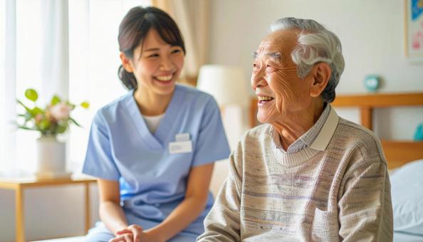 笑顔で話をする女性介護士と高齢男性の写真