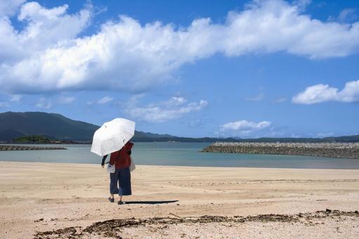 <素材>夏の海水浴場で遊ぶ日傘の女性 <素材>夏の海水浴場で遊ぶ日傘の女性 女性,人物,夏の写真素材