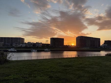 綺麗な朝日と雲 川と芝生 綺麗な朝日と雲 川と芝生の写真