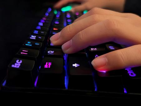 ゲーミングキーボードをタイピングする手元 ゲーミングキーボードをタイピングする手元の写真
