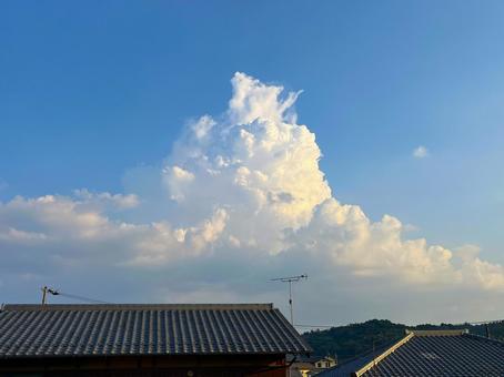 夕陽を浴びる入道雲 夕陽を浴びる入道雲 入道雲,町並み,街並みの写真素材
