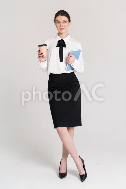 ノートとコーヒーを持つメガネ女性 女性,コーヒー,飲み物の写真素材