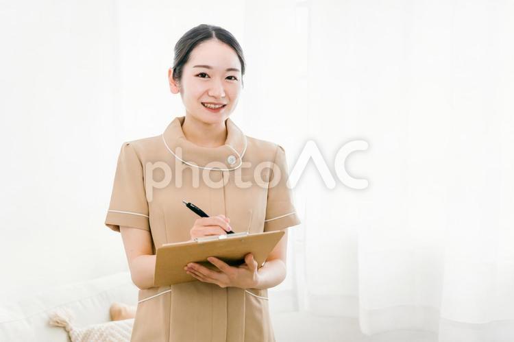 受付をするサロンスタッフの女性（カルテ） 受付,カウンセラー,カウンセリングの写真素材