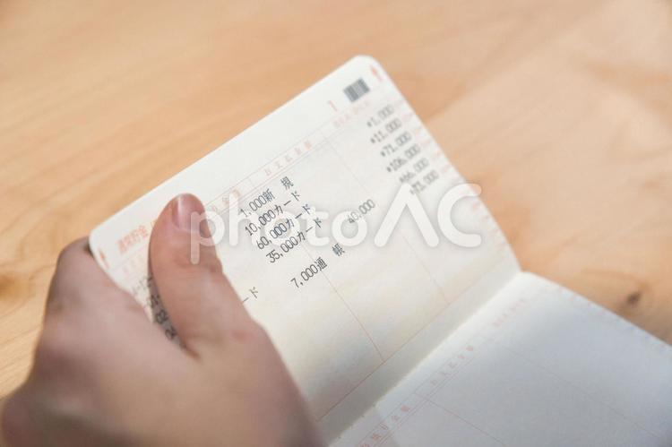 通帳の残高を確認する人 貯金,通帳,お金の写真素材