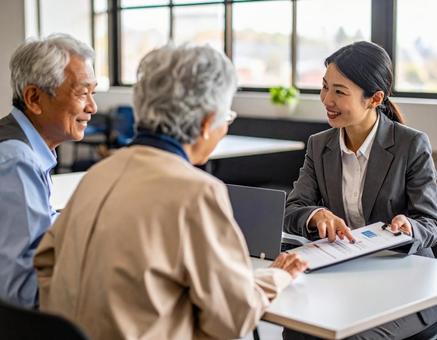 夫婦と打ち合わせするビジネスウーマン 夫婦と打ち合わせするビジネスウーマンの写真