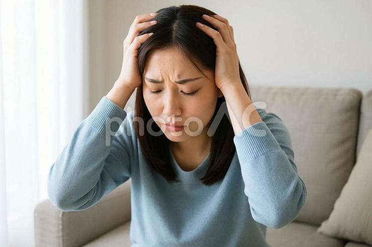 部屋で頭を抱えうつ病・体調不良に悩む女性 うつ病,女性,頭を抱えるの写真素材