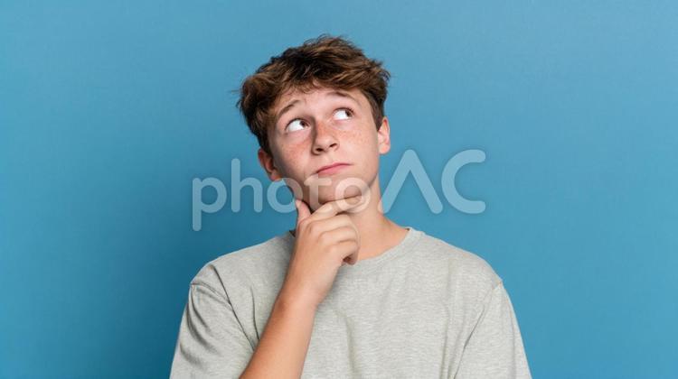 上を見上げ、何かに思いを馳せる若者 ティーンエイジャー,若者,男性の写真素材