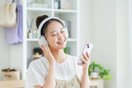 音楽を聴く若い女性 音楽,スマホ,笑顔の写真素材