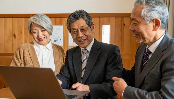 対面でPCでプランを説明するビジネスマンの写真