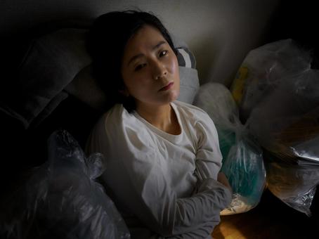 34:ゴミに囲まれている女性 34:ゴミに囲まれている女性 ゴミ部屋,ゴミ屋敷,汚部屋の写真素材
