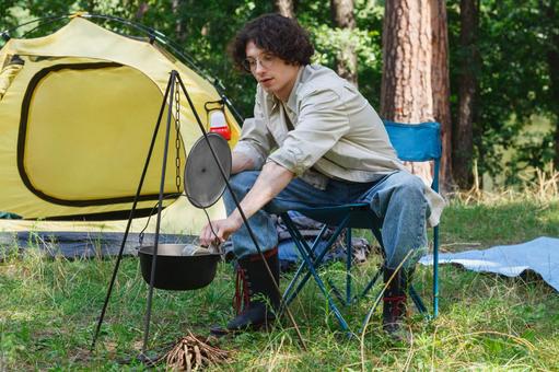 テントの前で鍋を見る男性 男性,外国人,鍋の写真素材