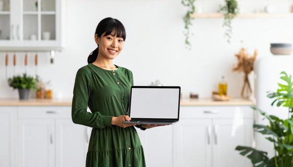 ノートパソコンを持つおしゃれな日本人女性 ノートパソコンを持つおしゃれな日本人女性の写真