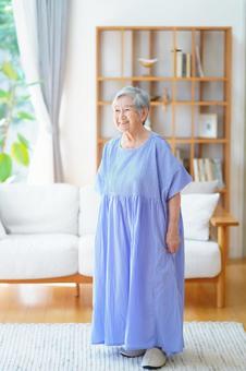 ラグの上に立つ青いワンピースの高齢女性 女性,立つ,穏やかの写真素材