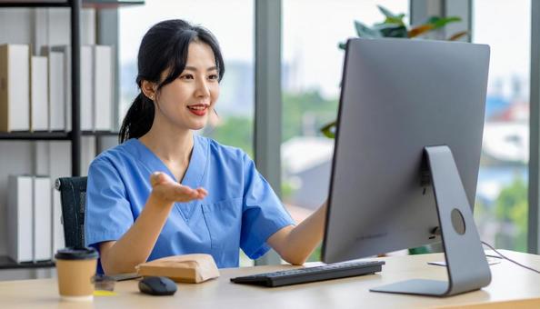 パソコンに向かって話す女性の写真