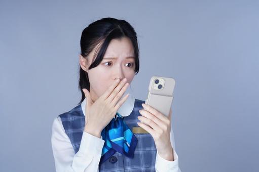 グレーの服の女性がスマホを覗く 女性,スマートフォン,持つの写真素材