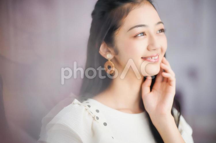 頬を触りポーズをする女性 女性,頬を触る,ポーズの写真素材