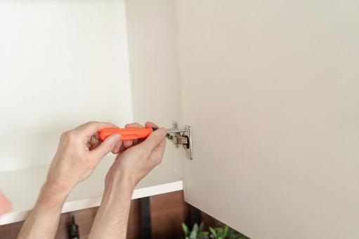 扉のネジを締める手 扉のネジを締める手の写真