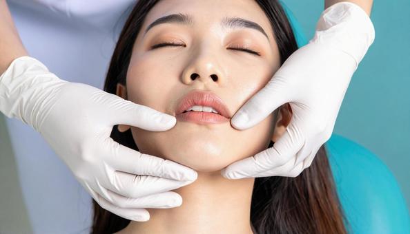 歯医者で患者の歯肉を指で歯肉マッサージの写真