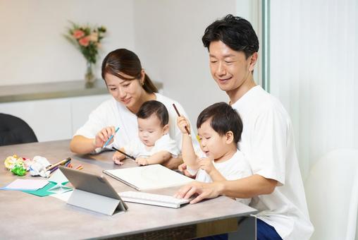 パソコンを操作する父親とそばで遊ぶ家族 パソコンを操作する父親とそばで遊ぶ家族 子育て,育児,ノートパソコンの写真素材