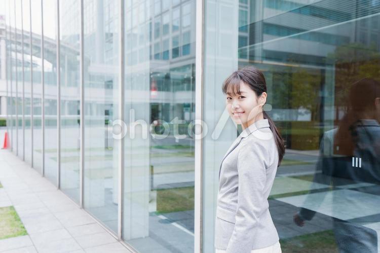 オフィス街を歩く若いビジネスウーマン スッキリ,考え事,笑顔の写真素材