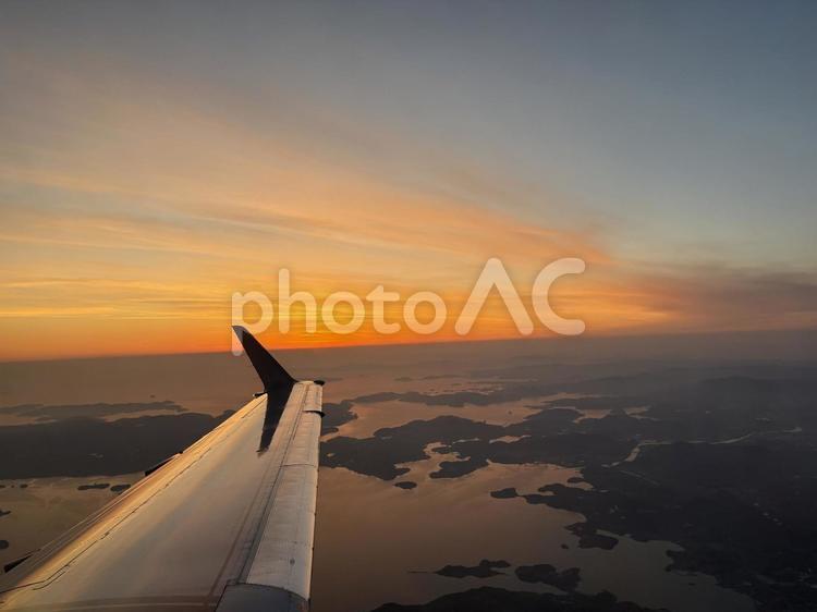 飛行機の窓から見た夕焼けと雲 飛行機,景色,上空の写真素材