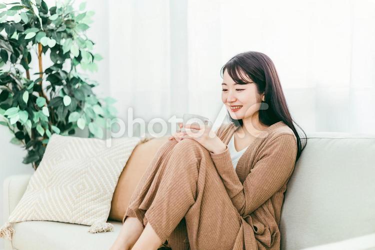ホットドリンクを飲む女性（お茶・温活） コーヒー,ソファ,女性の写真素材