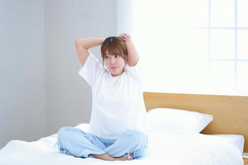 胡坐でストレッチをしているベッドの女性 女性,ストレッチ,ベッドの写真素材