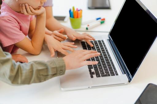 パソコンを操作する人の手元と頬杖をつく女の子 鼻から下,男の子,女の子の写真素材