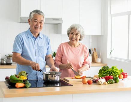キッチンで会話しながら料理するシニア夫婦 キッチンで会話しながら料理するシニア夫婦の写真