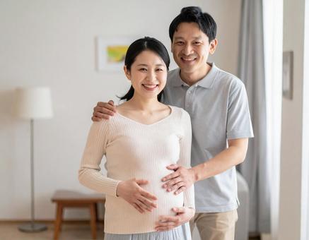 妊娠中の妻と幸せそうに寄り添う夫婦 妊娠中の妻と幸せそうに寄り添う夫婦の写真