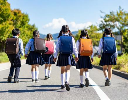 通学中の子供達の後ろ姿 通学中の子供達の後ろ姿の写真