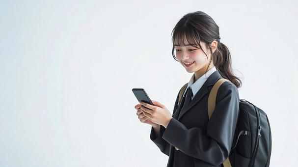 歩きながらスマートフォンを使う女子生徒 歩きながらスマートフォンを使う女子生徒の写真
