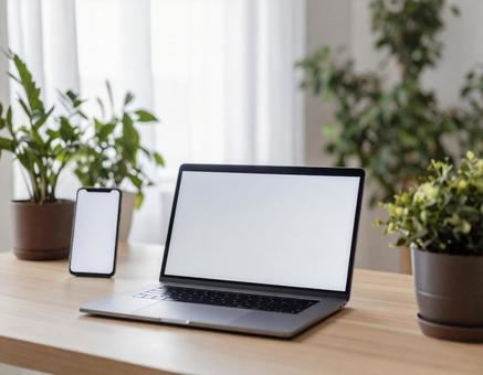 ノートパソコンとスマホでのリモートワークの写真