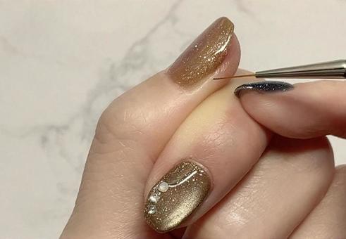 ジェルネイルを塗る女性の手元（細筆） ジェルネイル,細筆,女性の手の写真素材