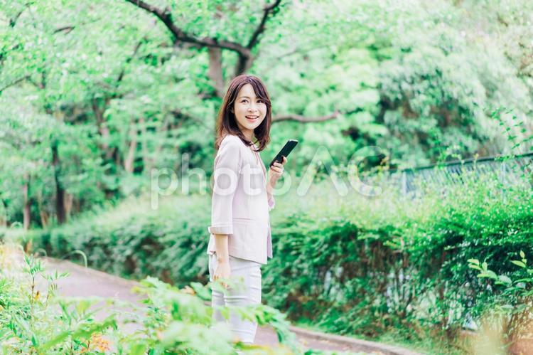 外でスマホを使うビジネスウーマン 操作,着信,日本人の写真素材