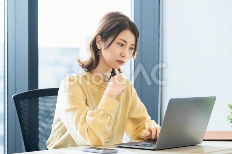 パソコンの画面を見ながら考える女性 女性,ビジネス,パソコンの写真素材