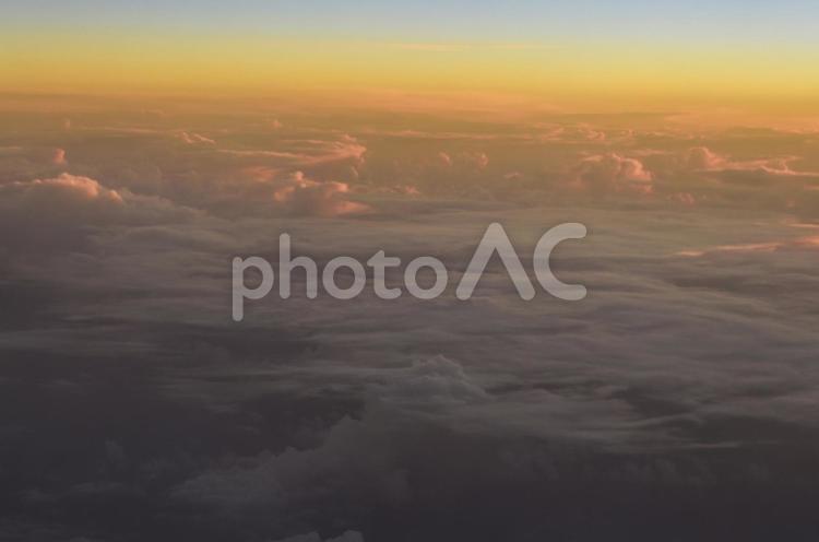 飛行機から見る朝焼けの空と雲海 朝焼け,オレンジ,青の写真素材