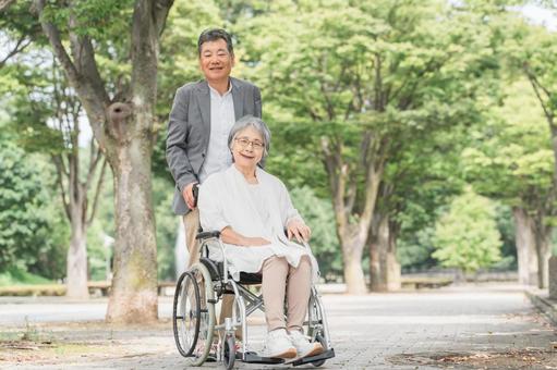 車椅子で公園を散歩するシニア・高齢者夫婦 介護,車椅子,夫婦の写真素材
