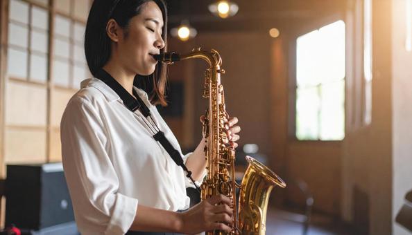 バリトンサックスを演奏する女性 バリトンサックスを演奏する女性の写真